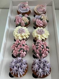 Caixa de cupcakes com cobertura floral em tons de lilás e verde