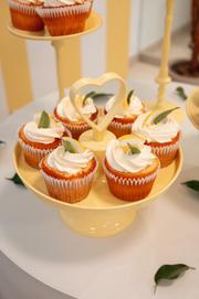 Cupcakes temáticos em suporte amarelo na mesa de festa
