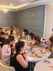 Grupo decorando bentô cakes ao redor de mesas redondas